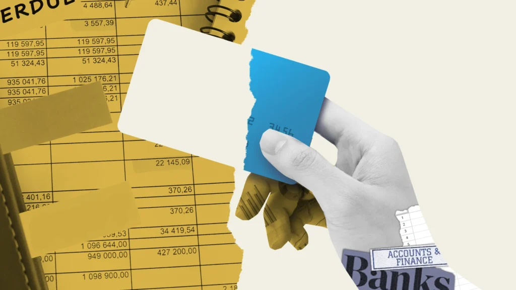 Hand tearing a blue credit card in front of financial documents with numbers and the words Accounts & Finance and Banks.